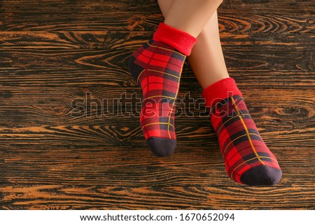 Legs of woman in socks on wooden background