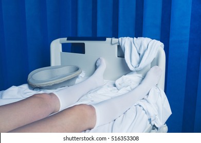 The Legs Of A Woman Wearing Compression Socks In A Hospital Bed