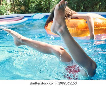 Legs Of A Young Boy On A Swimming Pool, Into The Water, No Faces Shown