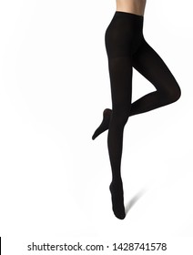 Legs of young caucasian woman in black nylon tights on white background