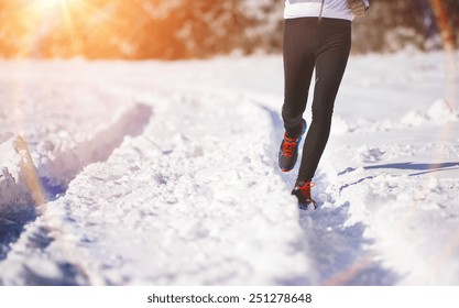 Legs of young sportsman jogging outside in a winter park - Shutterstock ID 251278648