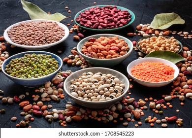 Legumes assortment on a black background. Lentils, soybeans, chickpeas, red kidney beans, a vatiety of pulses - Shutterstock ID 1708545223
