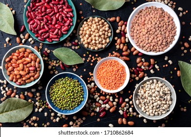 Legumes assortment, shot from the top on a black background. Lentils, soybeans, chickpeas, red kidney beans, a vatiety of pulses