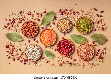 Legumes assortment, shot from the top on a brown background. Lentils, soybeans, chickpeas, red kidney beans, black-eyed peas, a vatiety of pulses - Shutterstock ID 1714690831