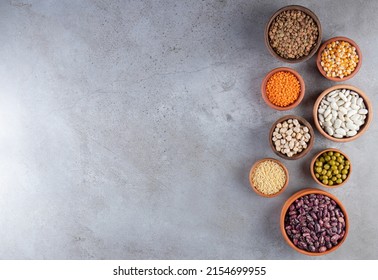 Legumes and beans assortment in different bowls on light stone background . Top view copy space. Healthy vegan protein food, colorful legumes in bowls, lentils, kidney beans, chickpeas, mung, peas. - Shutterstock ID 2154699955