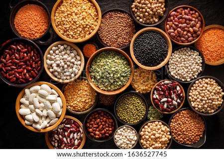 Legumes, a set consisting of different types of beans, lentils and peas on a black background, top view. The concept of healthy and nutritious food