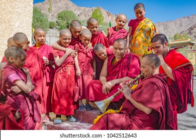 Leh, India-June 4 2017: Novice buddhist monks watching an older monk playing traditional Tibetan flute at the Likir monastery, Leh, north of India.