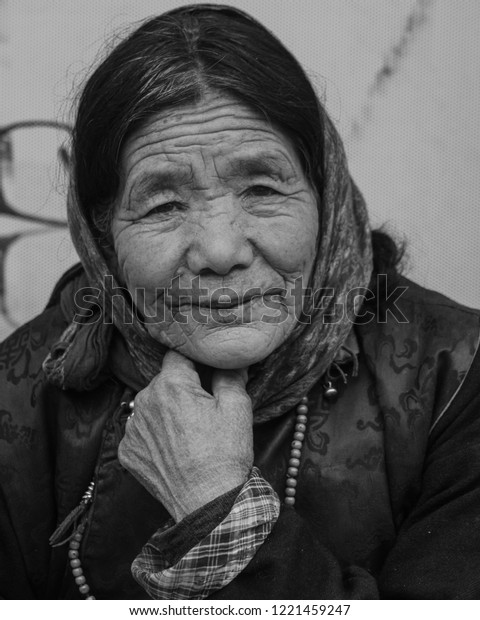Leh, Jammu & Kashmir - September 23, 2018:\
Portrait of an old, wrinkled lady selling novelty items in the Leh\
market (black and White)