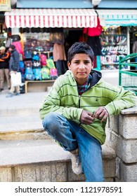 Leh Ladakh , India - April 17,2018 Illustrative Editorial. Indian Boy in Green Jacket and Blue Jeans Looking for Tourist Camera at Near Leh Ladakh Market.