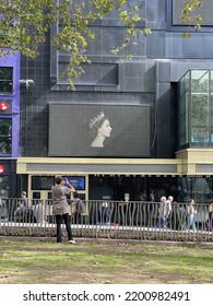 Leicester Square, London, UK. September, 12, 2022: A Screen Showing A Young Queen Elizabeth II In Memory Of Her Recent Death Shown In Leicester Square While An Onlooker Takes A Photograph.