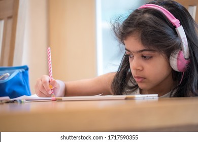 Leicester, UK. April 23 2020. A School Age Girl Completes Her Online School Lesson At Home Listening To The Teacher On An IPad During The Covid-19 Pandemic. 