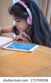 Leicester, UK. April 23 2020. A School Age Girl Completes Her Online School Lesson At Home Listening To The Teacher On An IPad During The Covid-19 Pandemic. 