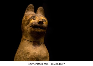 Leiden, The Netherlands - JAN 04, 2020: ancient cat mummy in a wooden cat sarcophagus figurine  painted with an eye of Horus amulet. Ancient egypt. Exhibition Gods of Egypt.