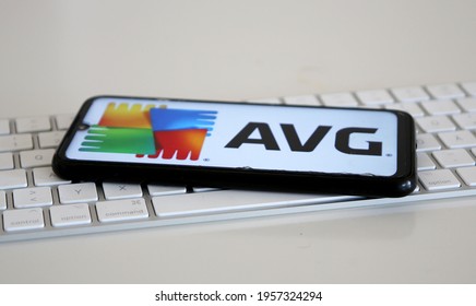 Leipzig, Germany - April 11, 2021: Closeup of smartphone screen with logo lettering of AVG on computer keyboard (focus on center upper lettering)