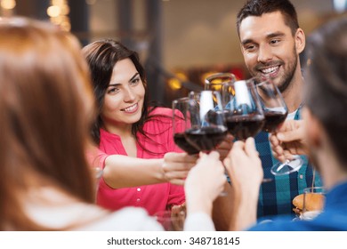 Leisure, Celebration, Drinks, People And Holidays Concept - Happy Couple And Friends Clinking Glasses Of Wine At Restaurant