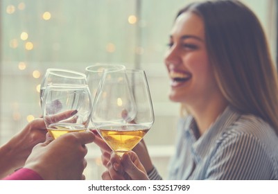 leisure, celebration, drinks, people and holidays concept - happy couple and friends clinking glasses of wine at restaurant