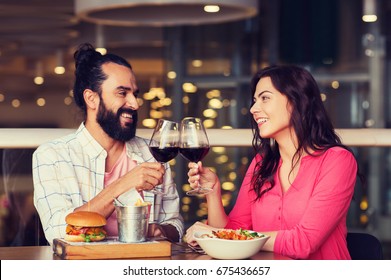 Leisure, Celebration, Food And Drinks, People And Holidays Concept - Smiling Couple Having Dinner And Drinking Red Wine At Date In Restaurant