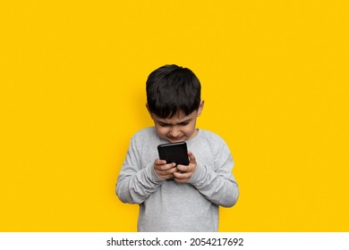 Leisure, Children, Technology And People Concept - Smiling Boy With Smartphone  Or Playing Game At Home Copy Space