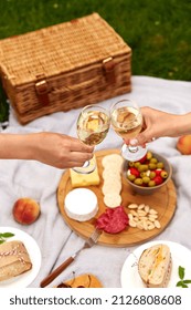 Leisure, Food And Drinks Concept - Close Up Of Hands Hands Clinking Wine Glasses Above Picnic Blanket At Summer Park