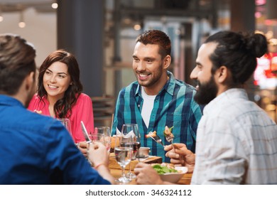 leisure, food and drinks, people and holidays concept - happy friends having dinner at restaurant - Powered by Shutterstock