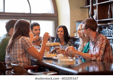 Leisure, Food, Drinks, People And Holidays Concept - Happy Friends Eating And Drinking At Bar Or Pub