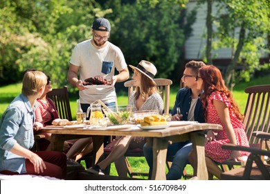 leisure, holidays, eating, people and food concept - happy friends having meat for dinner at summer garden party - Powered by Shutterstock