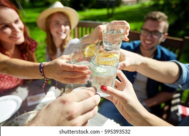 leisure, holidays, eating, people and food concept - happy friends having dinner at summer garden party and clinking drinks - Shutterstock ID 595393532
