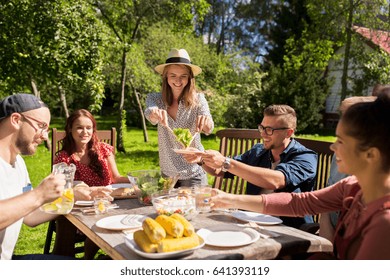 Leisure, Holidays, Eating, People And Food Concept - Happy Friends Having Dinner At Summer Garden Party