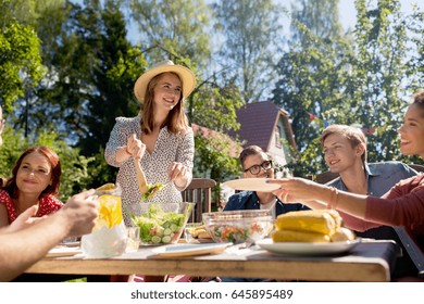 Leisure, Holidays, Eating, People And Food Concept - Happy Friends Having Dinner At Summer Garden Party