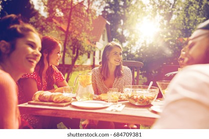 leisure, holidays, eating, people and food concept - happy friends having dinner at summer garden party - Powered by Shutterstock