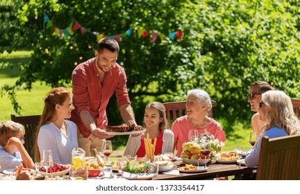 Leisure, Holidays And People Concept - Happy Family Having Festive Dinner Or Summer Garden Party