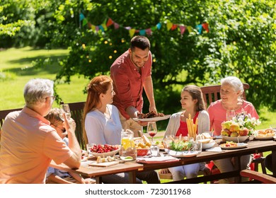 Leisure, Holidays And People Concept - Happy Family Having Festive Dinner Or Summer Garden Party