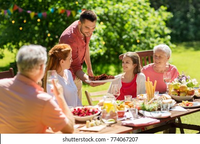 leisure, holidays and people concept - happy family having festive dinner or summer garden party