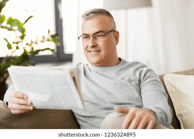 Leisure, Information, People And Mass Media Concept - Man Reading Newspaper At Home