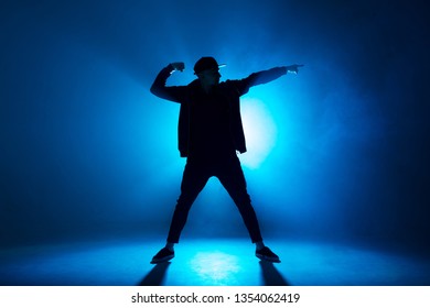 Leisure, Lifestyle, Hobby And Sport. Professional Male Dancer Dancing In Night Club With Smoke And Blue Neon Lights With Flare In Centre