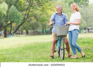 Leisure Lifestyle, Senior Couple Walking Their Bike Along Happily Talking, Older People Healthy Stand Happy Smile In The Park