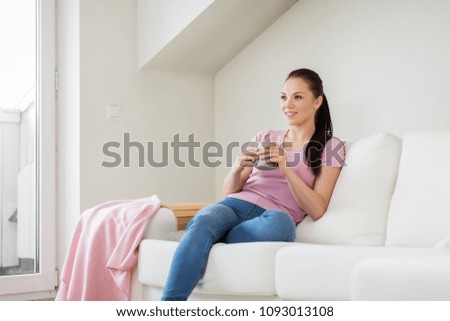 leisure and people concept - happy woman or housewife drinking coffee at home