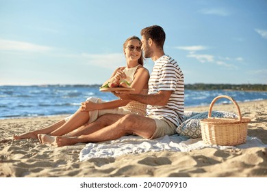 leisure, relationships and people concept - happy couple in sunglasses having picnic on summer beach - Powered by Shutterstock