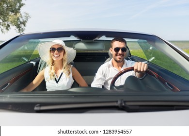 leisure, road trip, dating, couple and people concept - happy man and woman driving in cabriolet car outdoors - Powered by Shutterstock