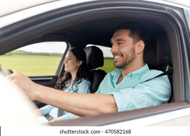 Leisure, Road Trip, Travel, Family And People Concept - Happy Man And Woman Driving In Car