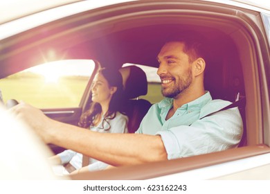 Leisure, Road Trip, Travel, Family And People Concept - Happy Man And Woman Driving In Car