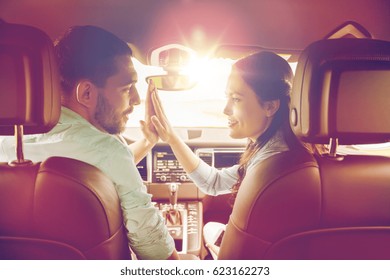 Leisure, Road Trip, Travel And People Concept - Happy Man And Woman Making High Five Gesture And Driving In Car