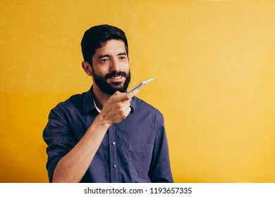 Leisure, technology, communication and people concept - young man using voice command recorder or calling on smartphone - Powered by Shutterstock