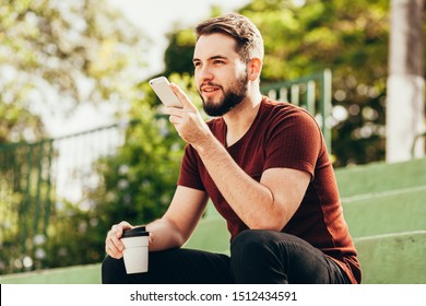 Leisure, technology, communication and people concept - young man using voice command recorder or calling on smartphone at street - Powered by Shutterstock