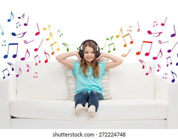 ocio, tecnología, música y concepto de infancia - niña sonriente con auriculares escuchando música sentada en el sofá sobre notas musicales