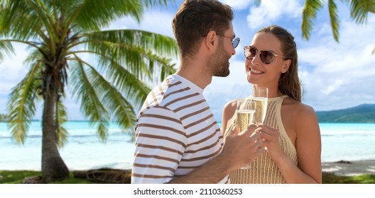 leisure, travel and tourism concept - happy couple in sunglasses drinking champagne over tropical beach background in french polynesia
