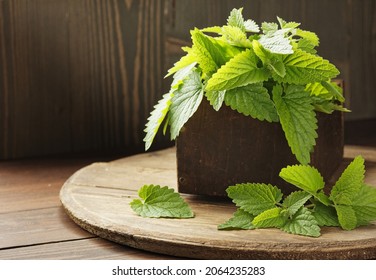 Lemon balm fresh herbal leaves on wooden rustic background, melissa officinalis herb is used for sleep, as digestive, anxiety, stress remedy, closeup, naturopathy and natural medicine concept