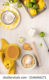 Lemon Cake Ingredients: Lemons, Limes, Crushed Cookies, Butter And More Laid Out On A Luminous Kitchen Wooden Table