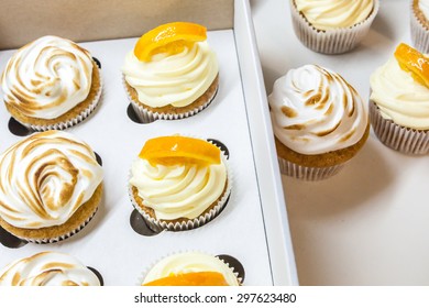Lemon cupcakes with meringue and orange cupcakes in a box - Shutterstock ID 297623480