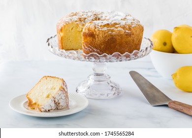 A Lemon Curd Bundt Cake On A Cake Stand With A Slice Of Cake On A Plate Ready For Eating.